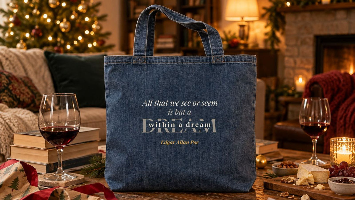 Poe Dream Within a Dream denim tote on a coffee table after a book club gift exchange, with wrapping paper and paperbacks