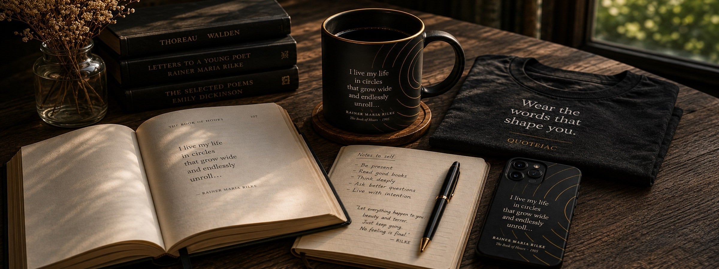 Desk with open books and quotes on mug and phone case