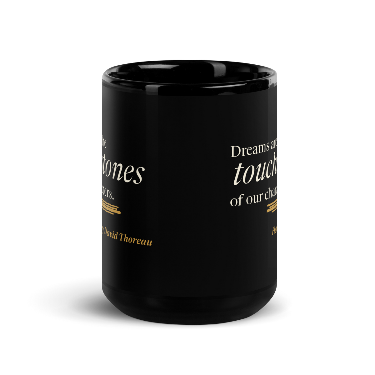 Black 15 oz mug, straight-on view: Thoreau's "Dreams are the touchstones of our characters." above a warm matte gold streak.