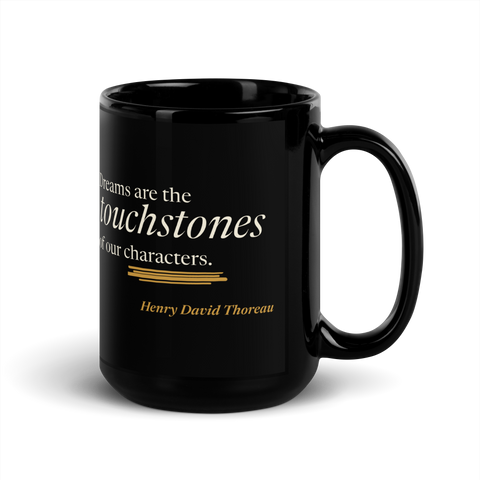 Black 15 oz mug, handle on right: Thoreau's "Dreams are the touchstones of our characters." above a warm matte gold streak.