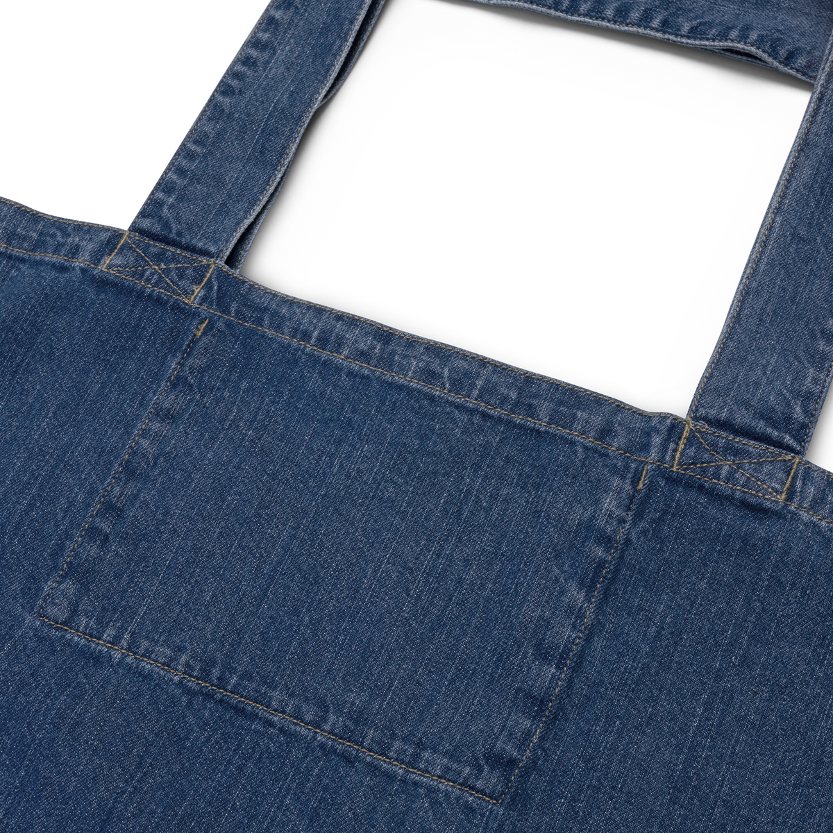 Indigo denim tote bag, back: plain denim with exterior front pocket visible.