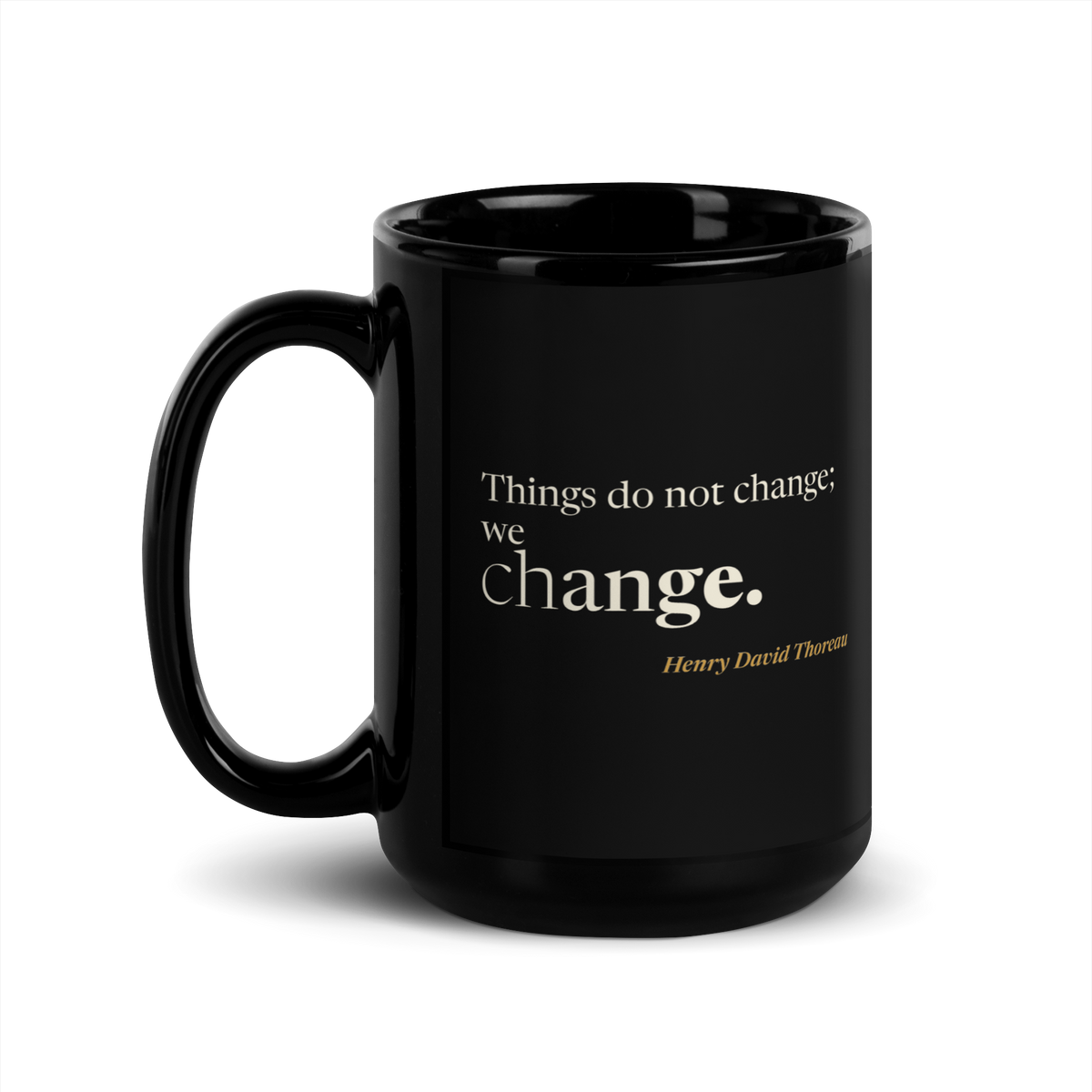Black mug, handle on the left, showing the same Thoreau line from Walden.