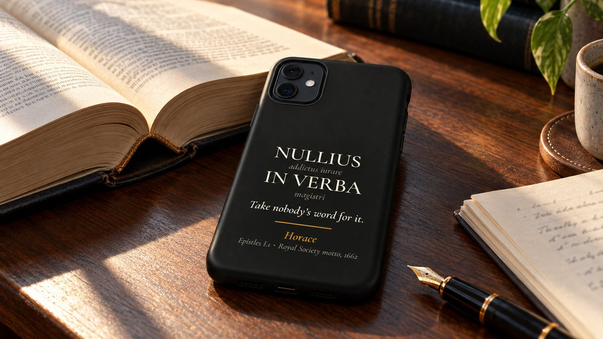 Black Nullius in Verba phone case on a law library desk beside an open book and a fountain pen