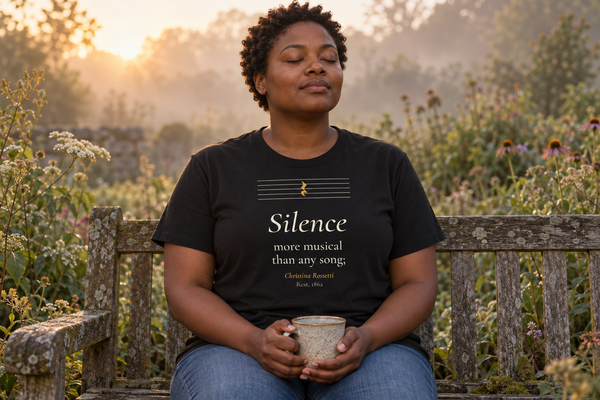 Woman on a garden bench at dawn wearing The Silence — Christina Rossetti tee.